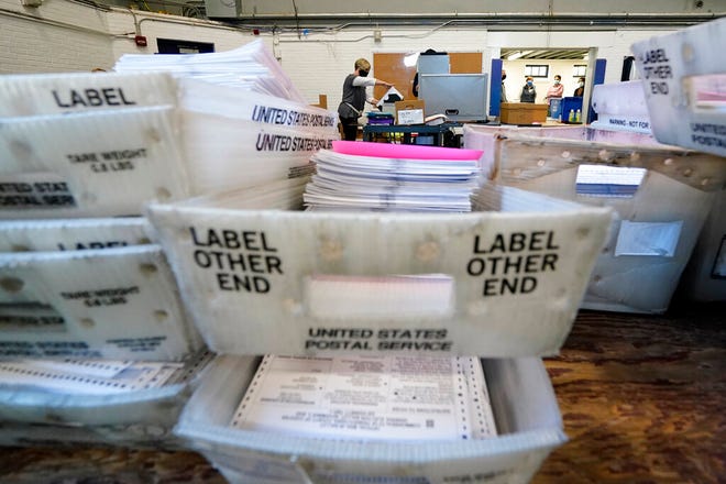 In this Nov. 4, 2020, file photo, Chester County election workers scan mail-in and absentee ballots for the 2020 general election in the United States at West Chester University, in West Chester, Pa.