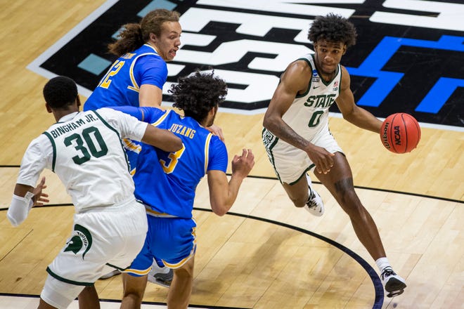 Michigan State's Aaron Henry (0) drives near teammate Marcus Bingham Jr. (30) as UCLA's Mac Etienne (12) and Johnny Juzang (3) defend during the first half.