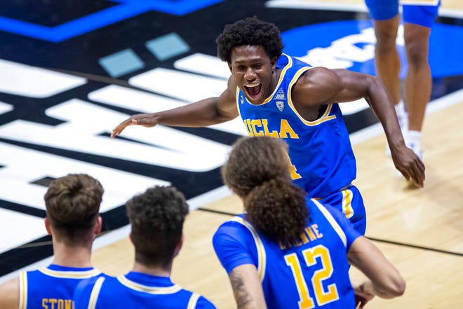 UCLA's David Singleton, top, runs to celebrate with teammates following their 86-80 win over Michigan State in a First Four game in the NCAA men's college basketball tournament, early Friday, March 19, 2021, at Mackey Arena in West Lafayette, Ind.