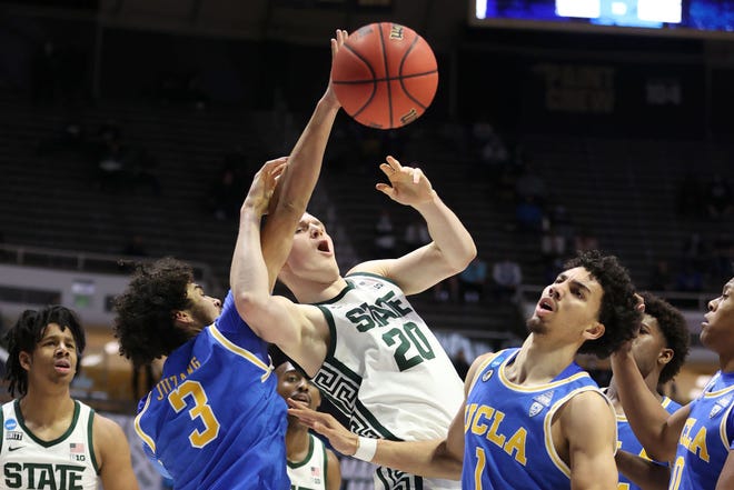 Johnny Juzang (3) of the UCLA Bruins fights for the ball against Joey Hauser (20) of the Michigan State Spartans during the second half.