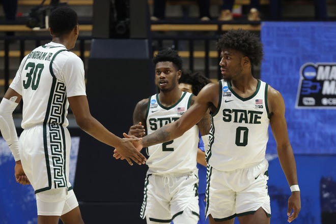 Aaron Henry (0) of the Michigan State Spartans celebrates a basket with teammates Marcus Bingham Jr. (30) and Rocket Watts (2) against the UCLA Bruins during the second half.
