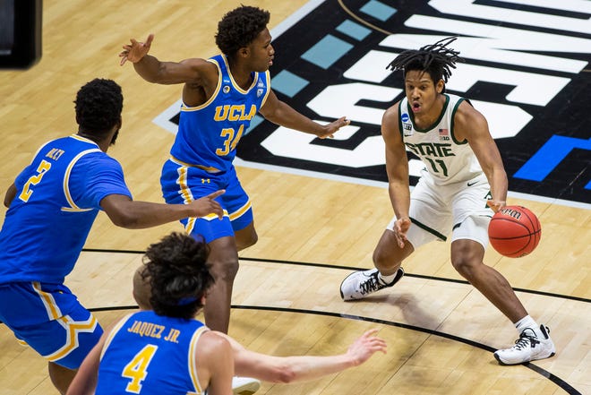 Michigan State's A.J. Hoggard (11) gets pressure from UCLA's Cody Riley (2), Jaime Jaquez Jr. (4) and David Singleton (34) during the first half.
