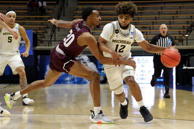 Mike Smith (12) of the Michigan Wolverines dribbles against Michael Weathers (20) of the Texas Southern Tigers during the second half.