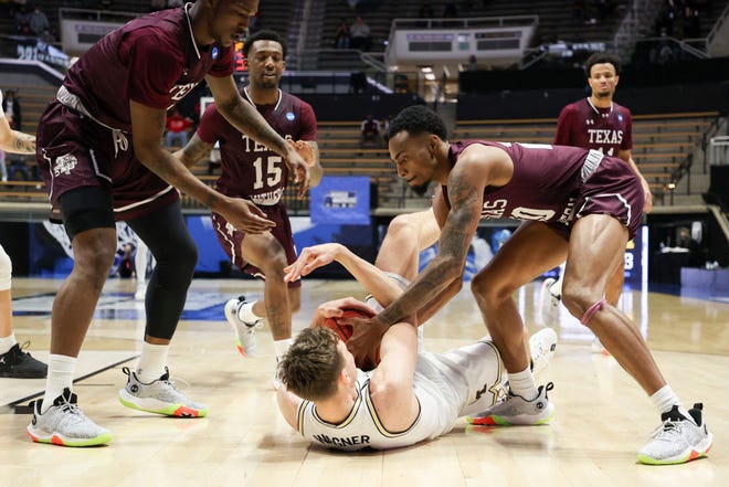 Franz Wagner (21) of the Michigan Wolverines and Michael Weathers (20) of the Texas Southern Tigers compete for a loose ball during the second half.