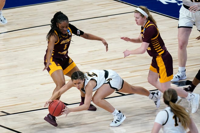 Iowa guard Gabbie Marshall, center, picks up a loose ball between Central Michigan's Anika Weekes, left, and Molly Davis, right, during the first half.