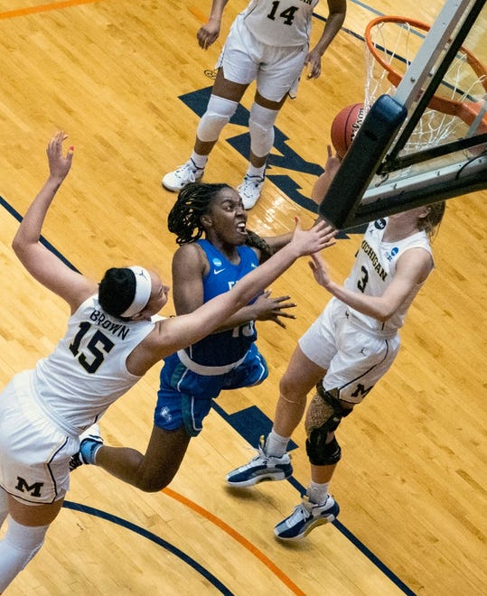 Florida Gulf Coast guard Trya Cox, center, puts up a shot between Michigan forward Hailey Brown, left, and forward Andrea Cecil right, during the third quarter.