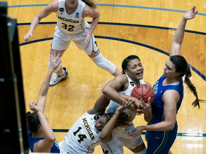 Michigan forward Naz Hilmon, center, fights for a rebound with Akienreh Johnson, left, against Florida Gulf Coast forward Andrea Cecil, right, during the third quarter.