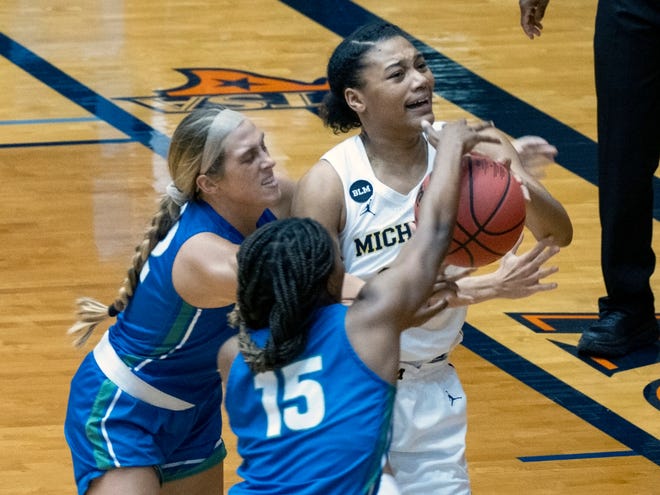 Michigan guard Naz Hilmon, right, goes up for a shot against Florida Gulf Coast guard Tyra Cox, center, and Emma List, left, during the first quarter.