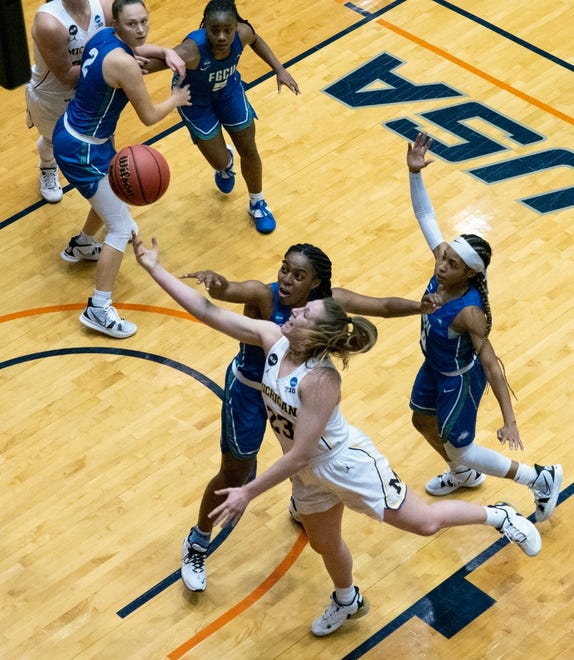 Michigan Danielle Rauch, front, shoots around Florida Gulf Coast guard Tyra Cox, back, and guard TK Morehouse, right, during the third quarter.