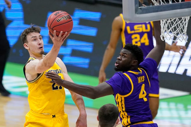 Michigan guard Franz Wagner, left, drives to the basket over LSU forward Darius Days (4) during the first half.