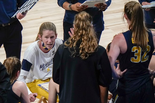 Michigan head coach Kim Barnes Arico talks to her players during the first half.
