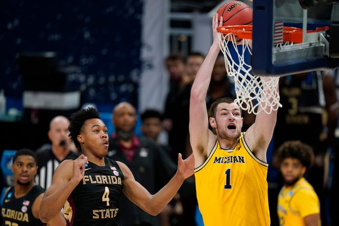 Michigan center Hunter Dickinson (1) dunks the ball ahead of Florida State guard Scottie Barnes (4) during the first half.