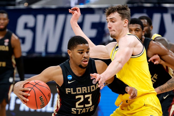 M.J. Walker of the Florida State Seminoles drives with the ball against Franz Wagner of the Michigan Wolverines in the second half.