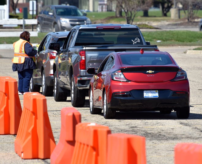 Motorists wait at least 15 minutes after receiving their vaccinations before leaving the area.