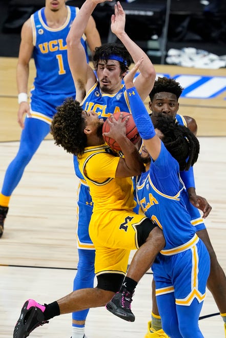 Michigan guard Mike Smith, left, is fouled by UCLA guard Tyger Campbell, right, during the first half.