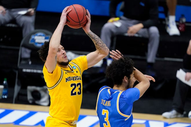 Michigan forward Brandon Johns Jr. (23) shoots on UCLA Bruins guard Johnny Juzang (3) during the first half of an Elite 8 game of the NCAA men's college basketball tournament at Lucas Oil Stadium, Tuesday, March 30, 2021, in Indianapolis.