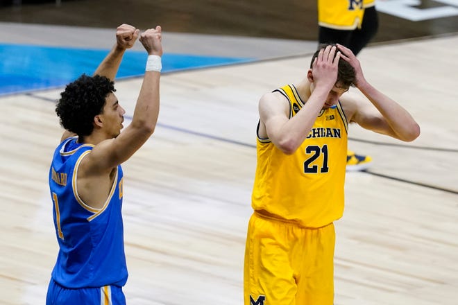 Michigan guard Franz Wagner (21) reacts in front of UCLA guard Jules Bernard, left, after missing a shot at the end of an Elite 8 game in the NCAA men's college basketball tournament at Lucas Oil Stadium, Wednesday, March 31, 2021, in Indianapolis. UCLA won 51-49.
