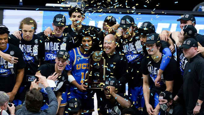 UCLA players and coaches celebrate after an Elite 8 game against Michigan in the NCAA men's college basketball tournament at Lucas Oil Stadium, Wednesday, March 31, 2021, in Indianapolis. UCLA won 51-49.