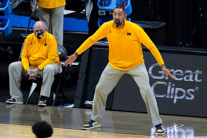 Michigan head coach Juwan Howard reacts to a play as assistant coach Phil Martelli looks on from the bench during the first half.