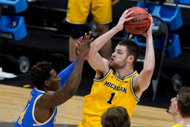 Michigan center Hunter Dickinson (1) shoots over UCLA forward Kenneth Nwuba, left, during the second half.