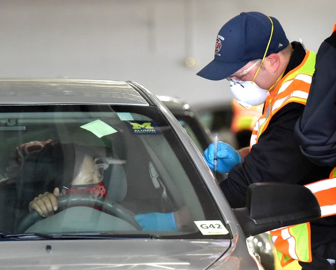 Shelby Township firefighter and medic David Grabski prepares to vaccinate a motorist.