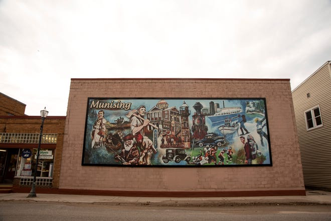 A mural celebrating the culture and history of Munising shown on Tuesday, March 30, 2021. It's located in downtown Munising on the side of the Madigan Hardware building.