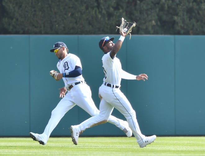 From left, Tigers center fielder Victor Reyes runs behind as left fielder Akil Baddoo calls for and makes a catch on a fly ball in the ninth inning.