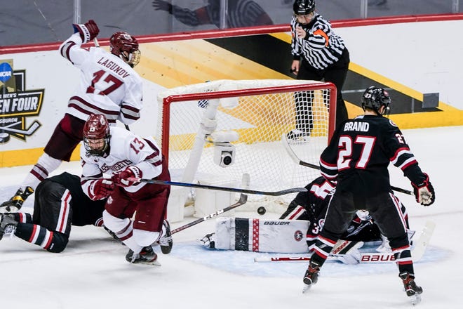 Massachusetts's Reed Lebster (13) celebrates after scoring against St. Cloud State during the first period of the NCAA men's Frozen Four hockey championship game in Pittsburgh, Saturday, April 10, 2021.