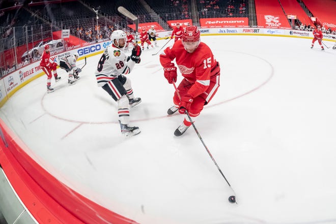 Detroit left wing Jakub Vrana keeps the puck away from Chicago left wing Vinnie Hinostroza in the second period during a game between the Detroit Red Wings and the Chicago Blackhawks, at Little Caesars Arena, in Detroit, April 15, 2021.