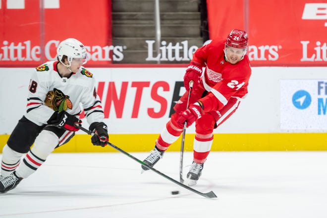 Detroit right wing Richard Panik and Chicago defenseman Wyatt Kalynuk battle for the puck in the third period during a game between the Detroit Red Wings and the Chicago Blackhawks, at Little Caesars Arena, in Detroit, April 15, 2021.