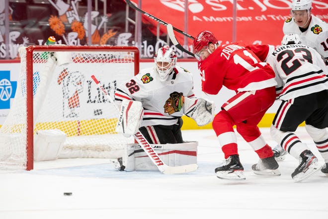 Detroit right wing Filip Zadina tries to play the puck in front of Chicago goaltender Kevin Lankinen in the third period during a game between the Detroit Red Wings and the Chicago Blackhawks, at Little Caesars Arena, in Detroit, April 15, 2021.
