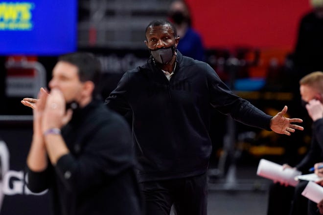Detroit Pistons head coach Dwane Casey, center, looks towards Oklahoma City Thunder head coach Mark Daigneault during the first half.