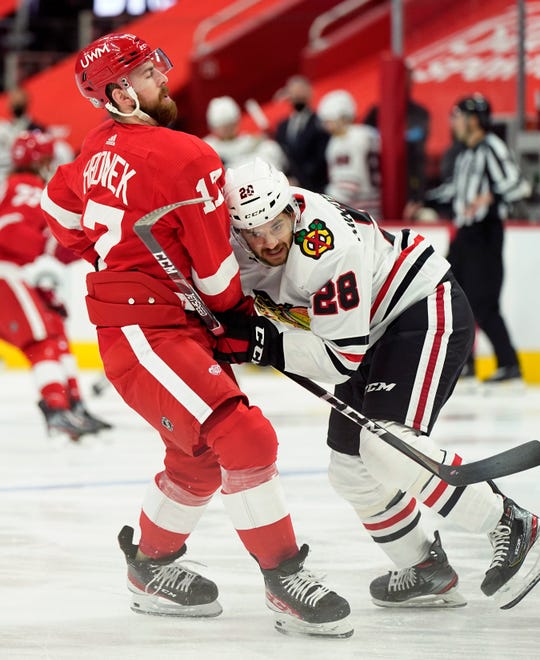 Detroit Red Wings defenseman Filip Hronek (17) checks Chicago Blackhawks left wing Vinnie Hinostroza (28) during the first period.