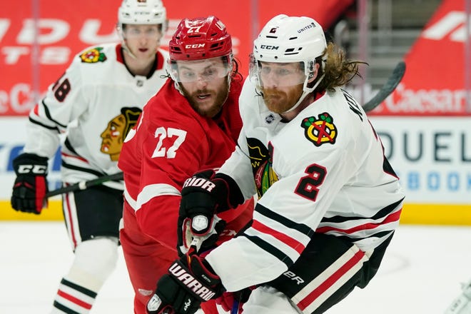 Detroit Red Wings center Michael Rasmussen (27) and Chicago Blackhawks defenseman Duncan Keith (2) try controlling the puck during the second period.