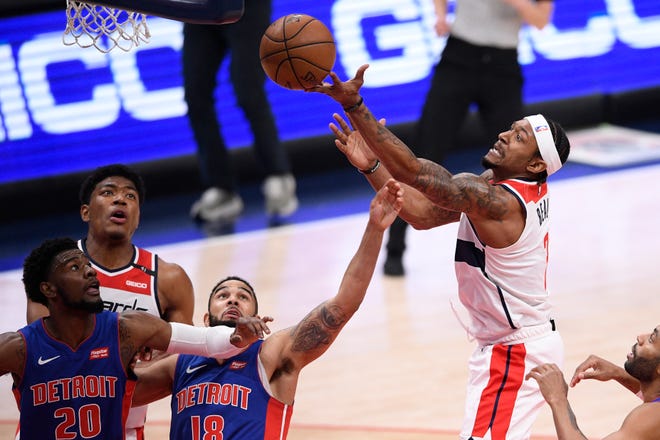 Washington Wizards guard Bradley Beal, right, reaches for the ball against Detroit Pistons guard Cory Joseph, center, and guard Josh Jackson, left, during the first half.