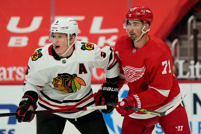 Chicago Blackhawks defenseman Connor Murphy (5) and Detroit Red Wings center Dylan Larkin (71) skate during the second period of an NHL hockey game, Saturday, April 17, 2021, in Detroit.