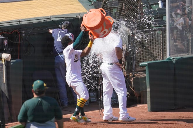 Oakland Athletics' Tony Kemp, left, pours water over Mitch Moreland after the Athletics defeated the Detroit Tigers.
