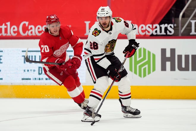 Chicago Blackhawks left wing Vinnie Hinostroza (28), defended by Detroit Red Wings defenseman Troy Stecher (70), passes the puck to right wing Patrick Kane, who scores during the first period.