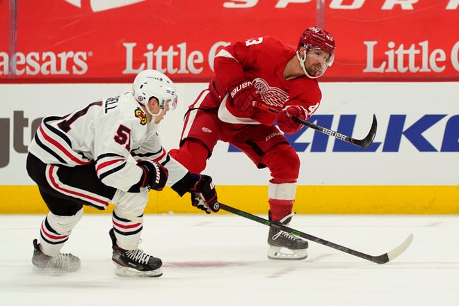 Detroit Red Wings left wing Darren Helm (43) shoots the puck as Chicago Blackhawks defenseman Ian Mitchell (51) defends during the second period.