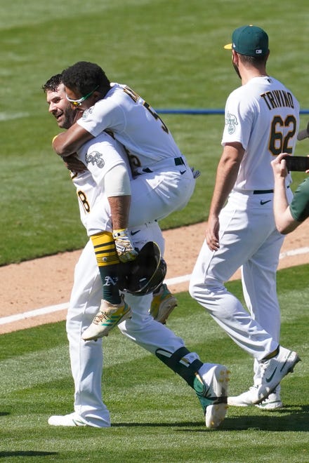 Oakland Athletics' Mitch Moreland, from left, Tony Kemp and Lou Trivino celebrate after the Athletics defeated the Detroit Tigers.