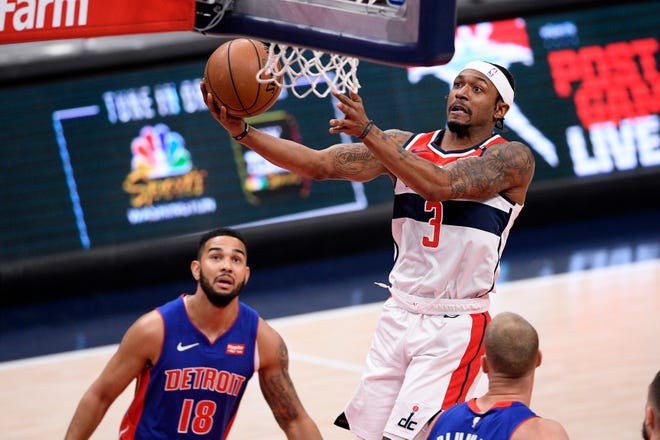 Washington Wizards guard Bradley Beal, center, goes to the basket against Detroit Pistons guard Cory Joseph, left, and center Mason Plumlee, right, during the first half of an NBA basketball game, Saturday, April 17, 2021, in Washington. The Wizards won the game, 121-100.