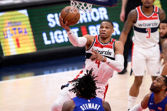 Washington Wizards guard Russell Westbrook (4) goes to the basket against Detroit Pistons center Isaiah Stewart, bottom, during the first half.