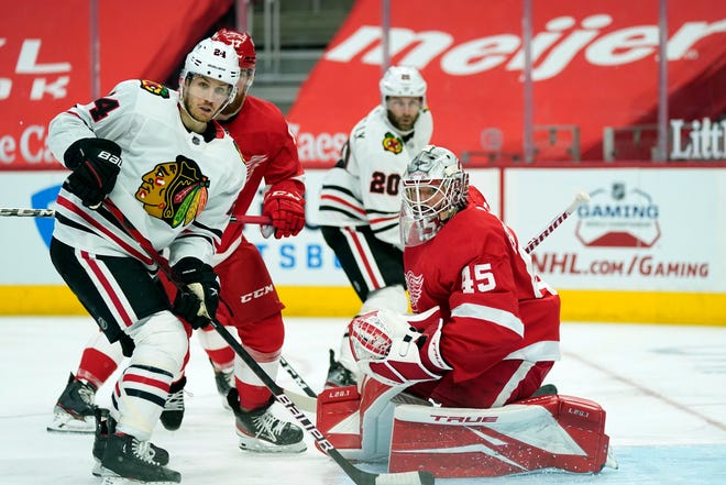 Chicago Blackhawks center Pius Suter (24) waits on a pass in front of Detroit Red Wings goaltender Jonathan Bernier (45) during the third period of an NHL hockey game, Saturday, April 17, 2021, in Detroit.
