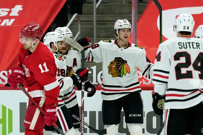 Chicago Blackhawks defenseman Wyatt Kalynuk, center, is greeted by teammates after scoring during the third period of an NHL hockey game against the Detroit Red Wings, Saturday, April 17, 2021, in Detroit.