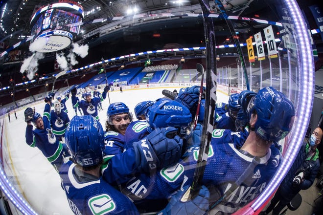 Vancouver Canucks' Bo Horvat is mobbed by teammates after scoring the winning goal during overtime.