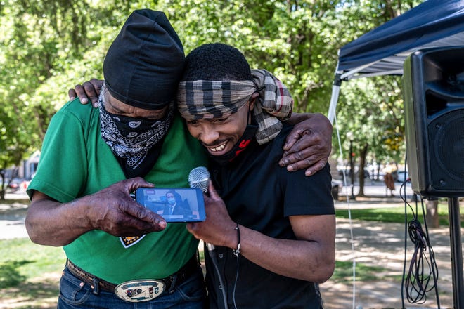 Stevante Clark, right, brother of Stephon Clark who was fatally shot by Sacramento Police, is hugged by his cousin Steven Ray Collins, left, at Cesar Chavez Park, Tuesday April 20, 2021, in Sacramento, Calif., as they listen live to the guilty verdict of former Minneapolis police Officer Derek Chauvin for the murder of George Floyd. A jury convicted Chauvin today on murder and manslaughter charges.