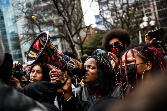 A woman chants into a megaphone as the verdict is announced in the trial of former police officer Derek Chauvin outside the Hennepin County Government Center in Minneapolis, Minnesota on April 20, 2021. - Sacked police officer Derek Chauvin was convicted of murder and manslaughter on april 20 in the death of African-American George Floyd in a case that roiled the United States for almost a year, laying bare deep racial divisions.