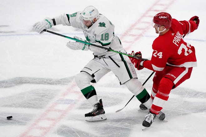 Dallas Stars center Jason Dickinson (18) attempts to reach a loose puck ahead of Detroit Red Wings right wing Richard Panik (24) in the first period of an NHL hockey game in Dallas, Tuesday, April 20, 2021.