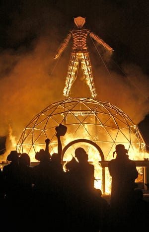In this Sept. 4, 2004 file photo the crowd of thousands cheer as the Burning Man is burned to the ground, at the 18th annual Burning Man Celebration, at Black Rock Desert.