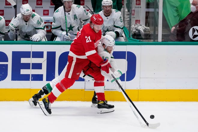 Detroit Red Wings defenseman Dennis Cholowski (21) and Dallas Stars center Joe Pavelski (16) compete for control of the puck in the first period of an NHL hockey game in Dallas, Tuesday, April 20, 2021.